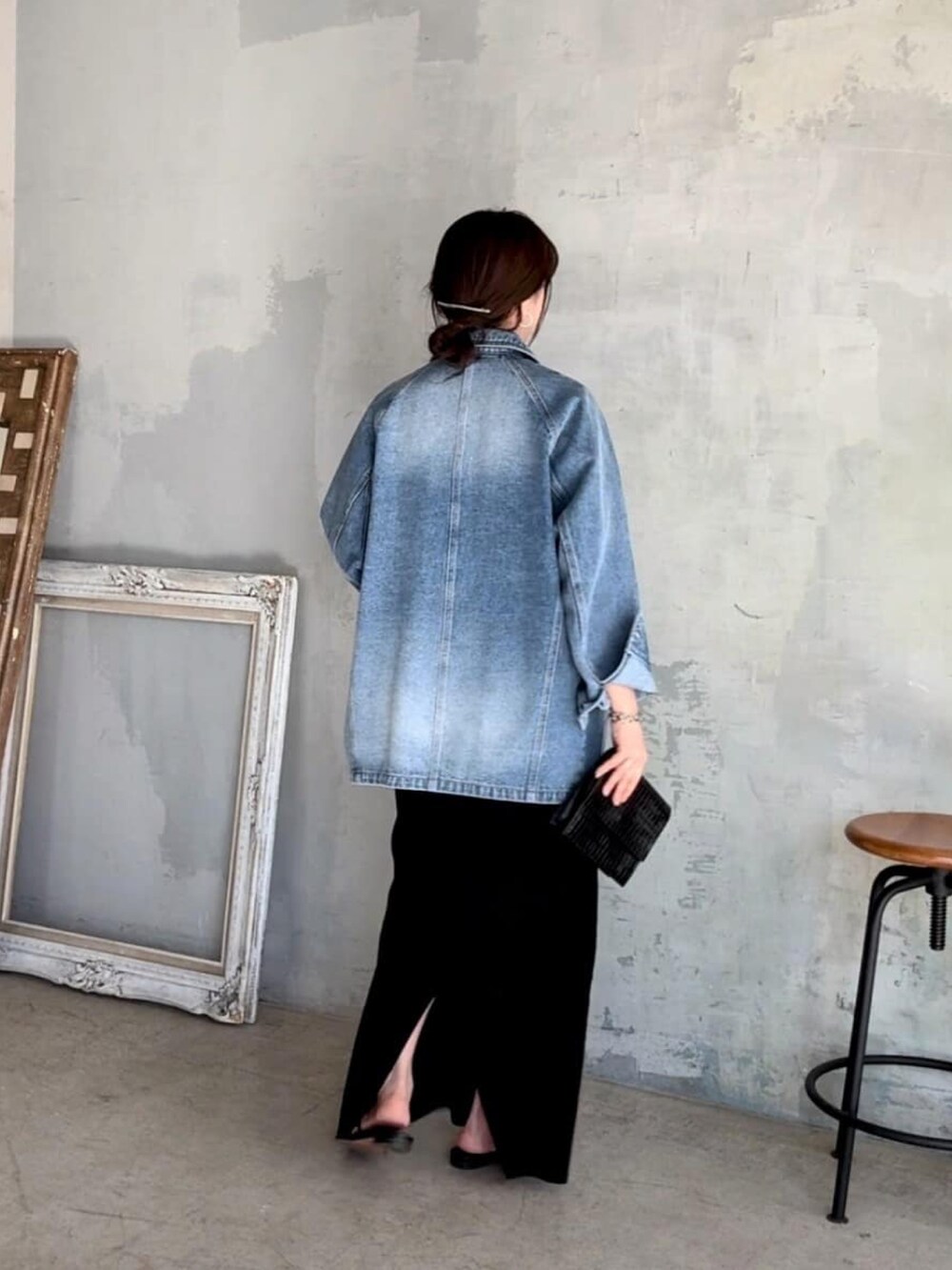 ブルー系のデニムジャケット、ブラック系のワンピース、ブラック系のサンダルを着用したレディースの春コーディネートの3枚目の写真