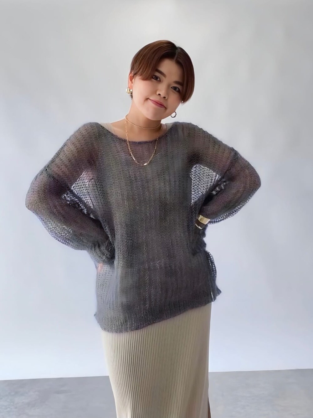 ベージュ系のワンピース、ホワイト系のニット/セーターを着用したレディースの秋コーディネートの2枚目の写真