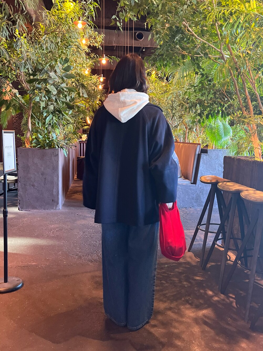 ブルー系のピーコート、ブルー系のデニムパンツ、グレー系のパーカーを着用したレディースの冬コーディネートの3枚目の写真