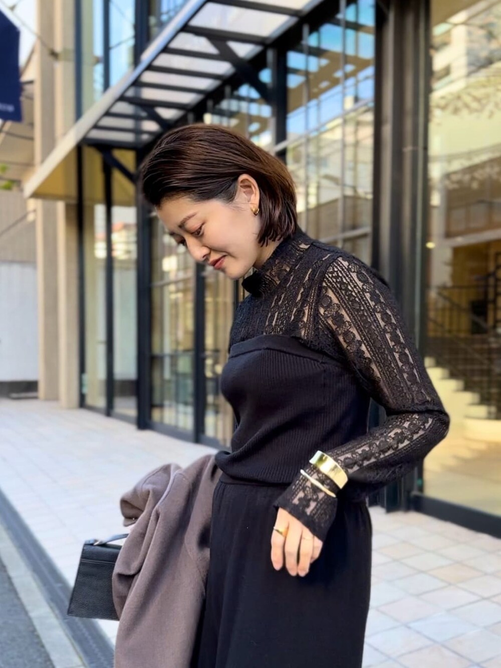 ブラック系のサロペット/オーバーオール、ブラック系のTシャツ/カットソー、ブラウン系のその他アウターを着用したレディースの冬コーディネートの3枚目の写真