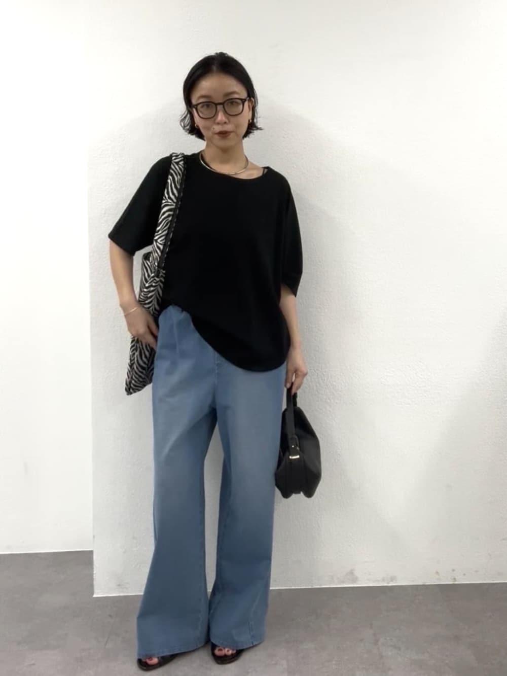 ブラック系のショルダーバッグ、ブラック系のTシャツ/カットソー、ブラック系のトートバッグを着用したレディースの春コーディネートの3枚目の写真