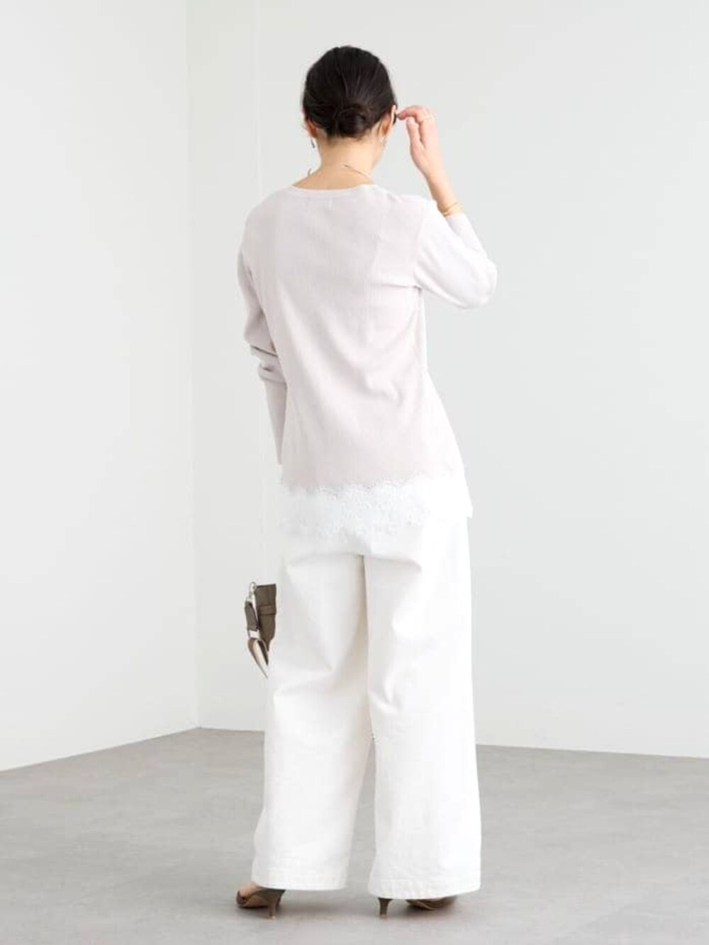 グレー系のトートバッグ、グレー系のその他シューズ、ホワイト系のデニムパンツを着用したレディースの冬コーディネートの4枚目の写真