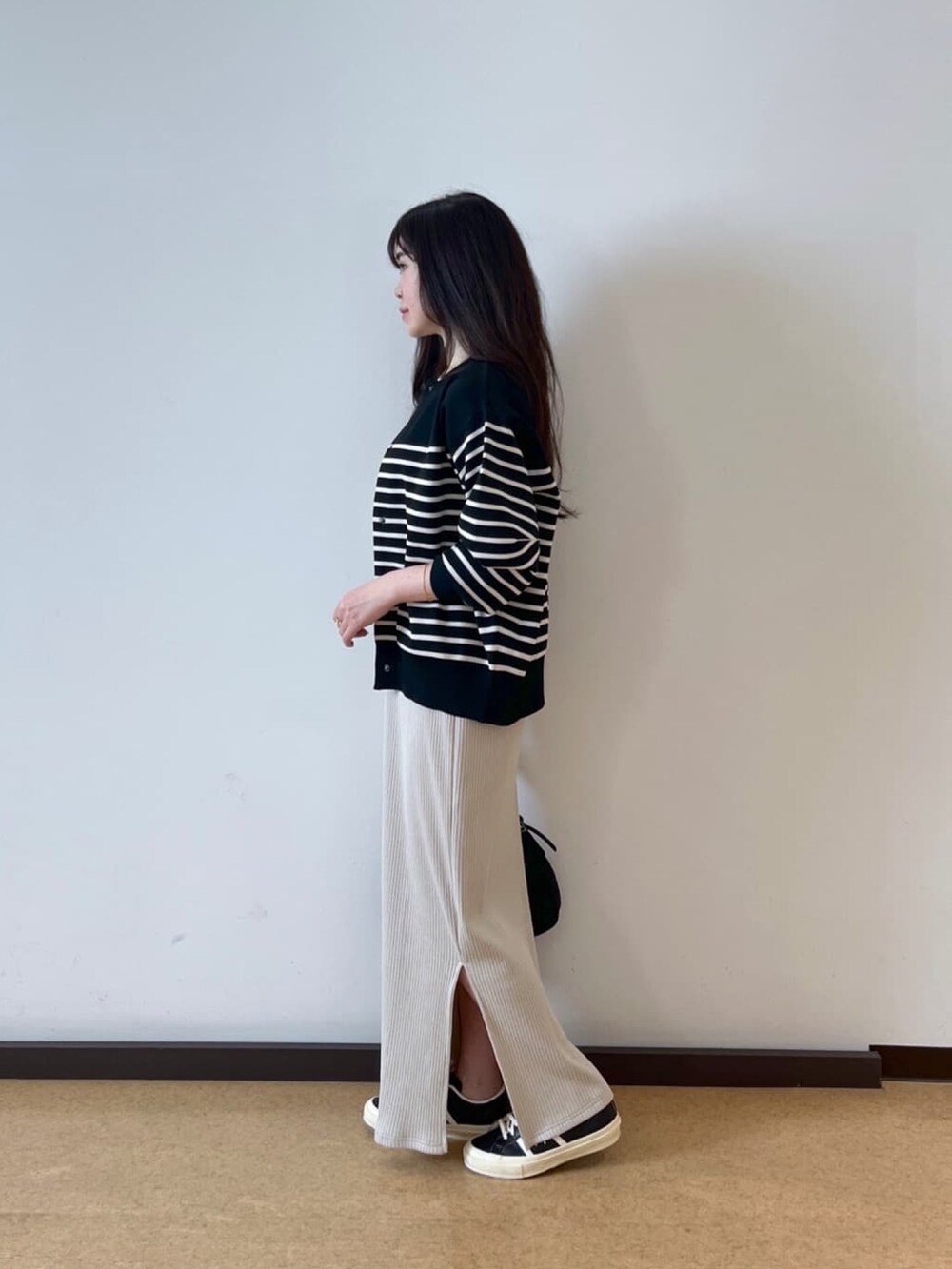 ベージュ系のワンピース、ブラック系のニット/セーターを着用したレディースの秋コーディネートの3枚目の写真