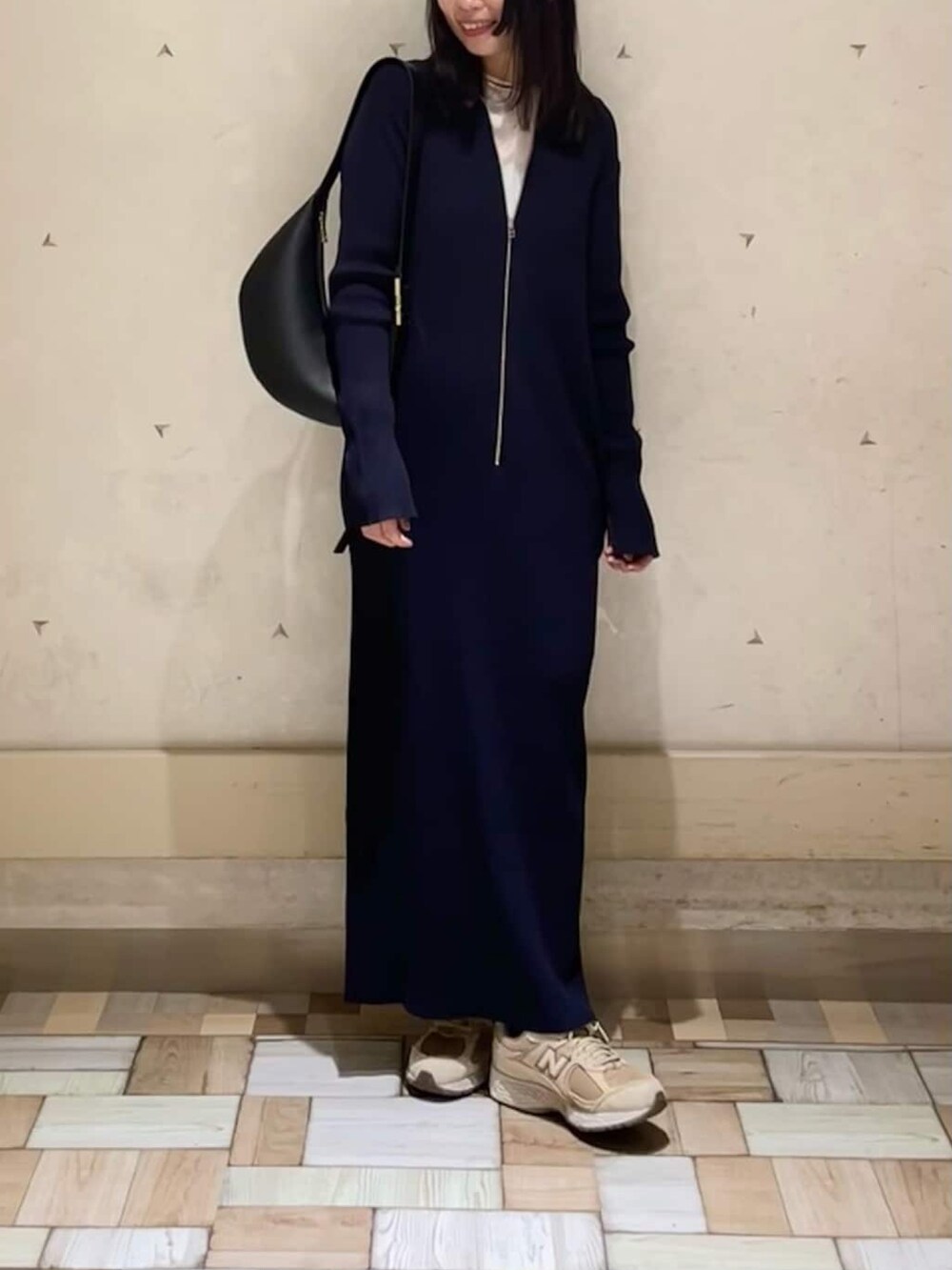 ブラック系のボディバッグ/ウエストポーチ、ブルー系のワンピース、ホワイト系のTシャツ/カットソーを着用したレディースの春コーディネートの3枚目の写真