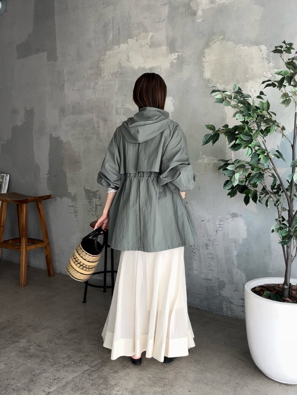 グリーン系のマウンテンパーカー、ベージュ系のスカート、ブラック系のサンダルを着用したレディースの夏コーディネートの3枚目の写真