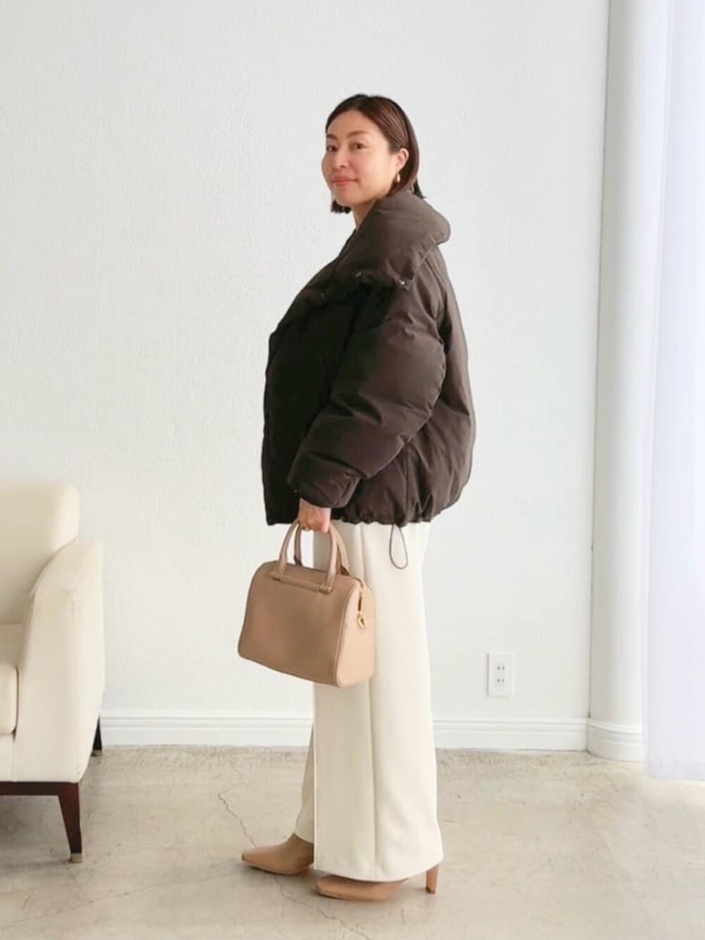 ブラウン系のダウンジャケット/コート、ベージュ系のバッグ、ホワイト系のその他パンツを着用したレディースの秋コーディネートの2枚目の写真