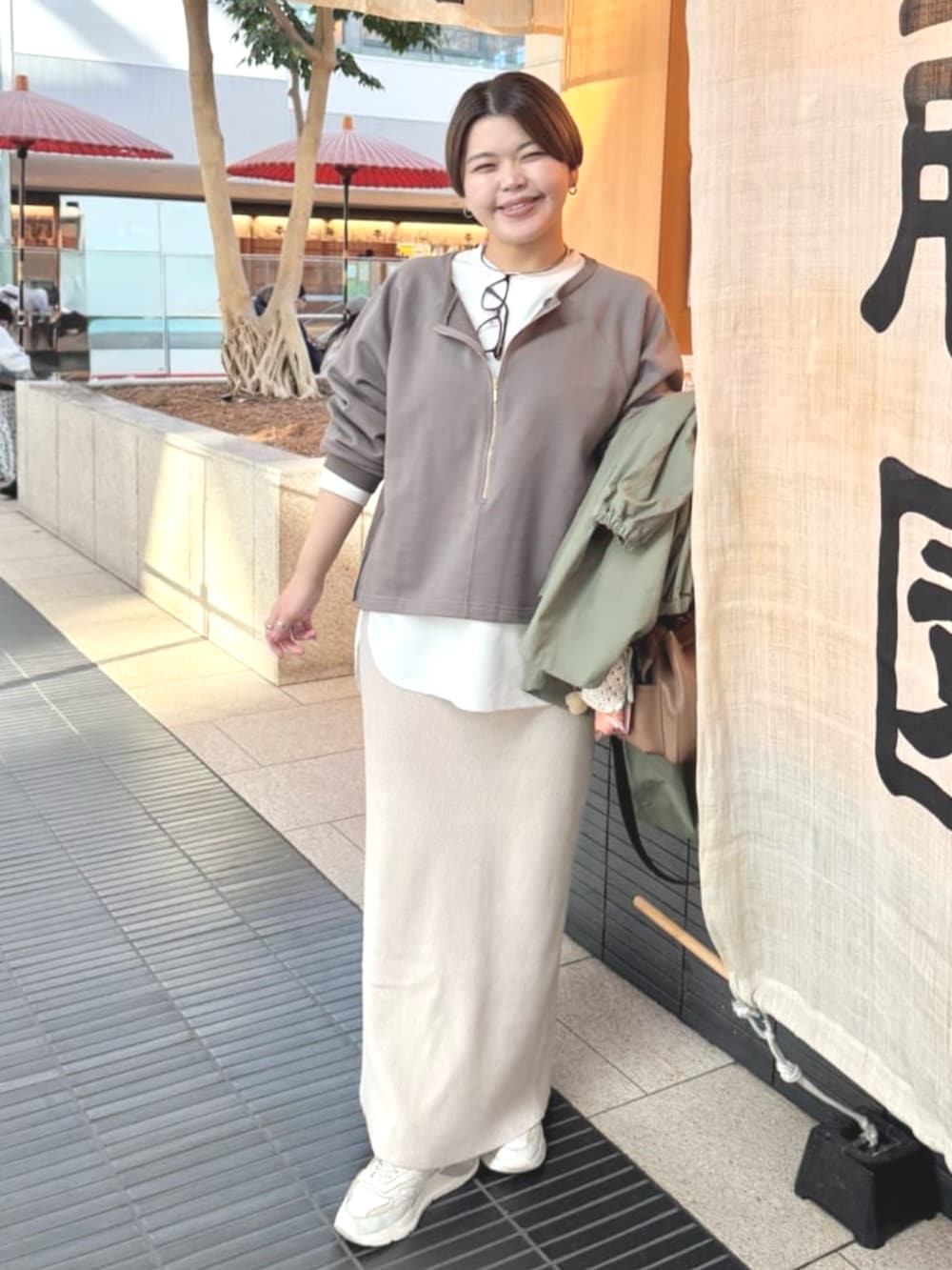 ホワイト系のTシャツ/カットソー、ホワイト系のスカート、グリーン系のその他アウターを着用したレディースの冬コーディネートの4枚目の写真