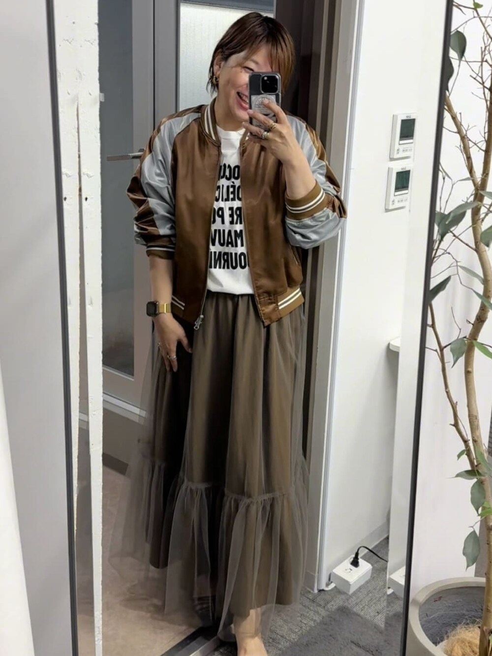 ブラウン系のブルゾン、ホワイト系のTシャツ/カットソー、ブラウン系のスカートを着用したレディースの夏コーディネートの2枚目の写真