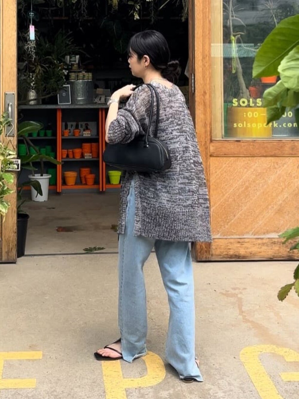 ブラック系のキャミソール、グレー系のカーディガン/ボレロ、ブルー系のデニムパンツを着用したレディースの夏コーディネートの4枚目の写真