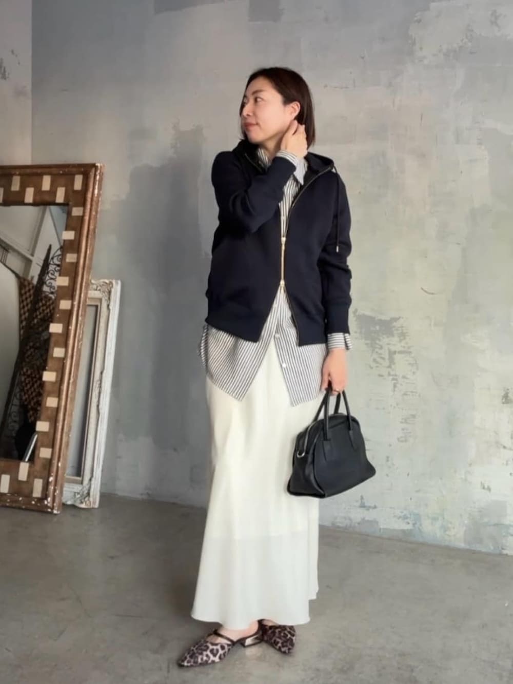 ブルー系のパーカー、ホワイト系のシャツ/ブラウス、ブラック系のボストンバッグを着用したレディースの冬コーディネートの4枚目の写真