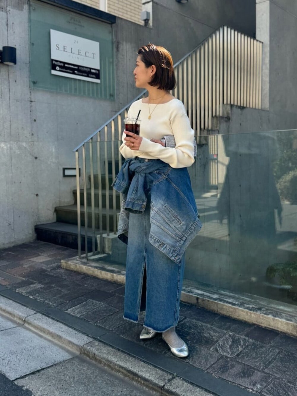 ブルー系のデニムジャケット、ブルー系のデニムスカート、グレー系のニット/セーターを着用したレディースの春コーディネートの2枚目の写真