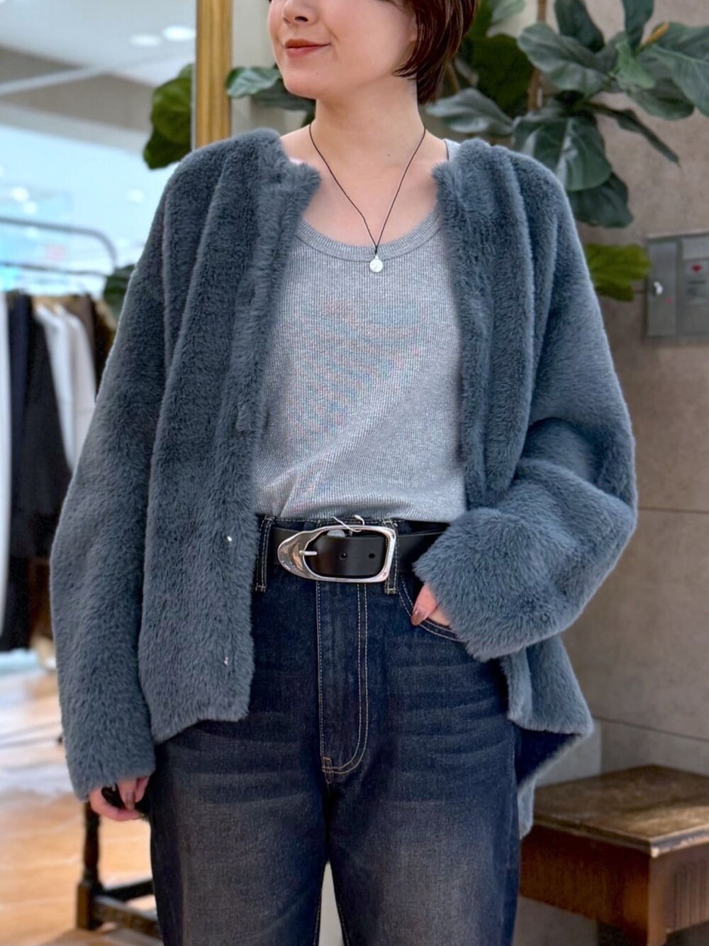 ブルー系のカーディガン/ボレロ、ブルー系のデニムパンツ、ブラック系のショルダーバッグを着用したレディースの秋コーディネートの4枚目の写真