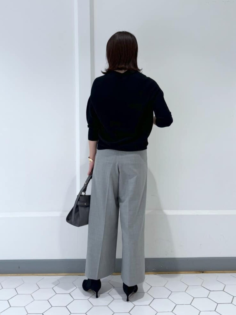 ブラック系のニット/セーター、グレー系のその他パンツ、ブラック系のブーツを着用したレディースの冬コーディネートの3枚目の写真