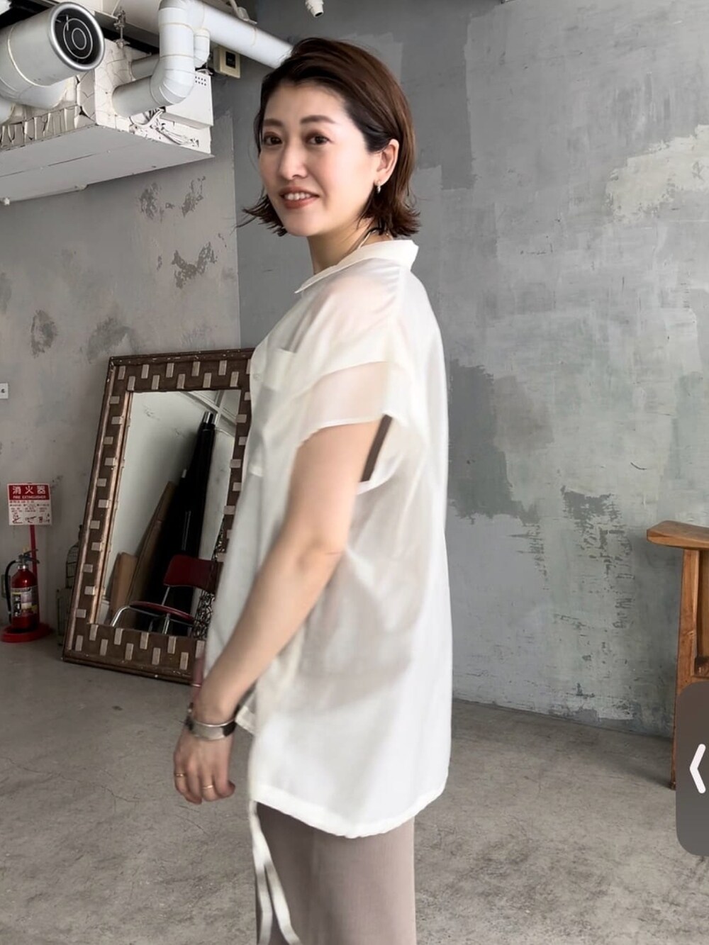 グリーン系のワンピース、シルバー系のサンダル、ホワイト系のシャツ/ブラウスを着用したレディースの春コーディネートの3枚目の写真