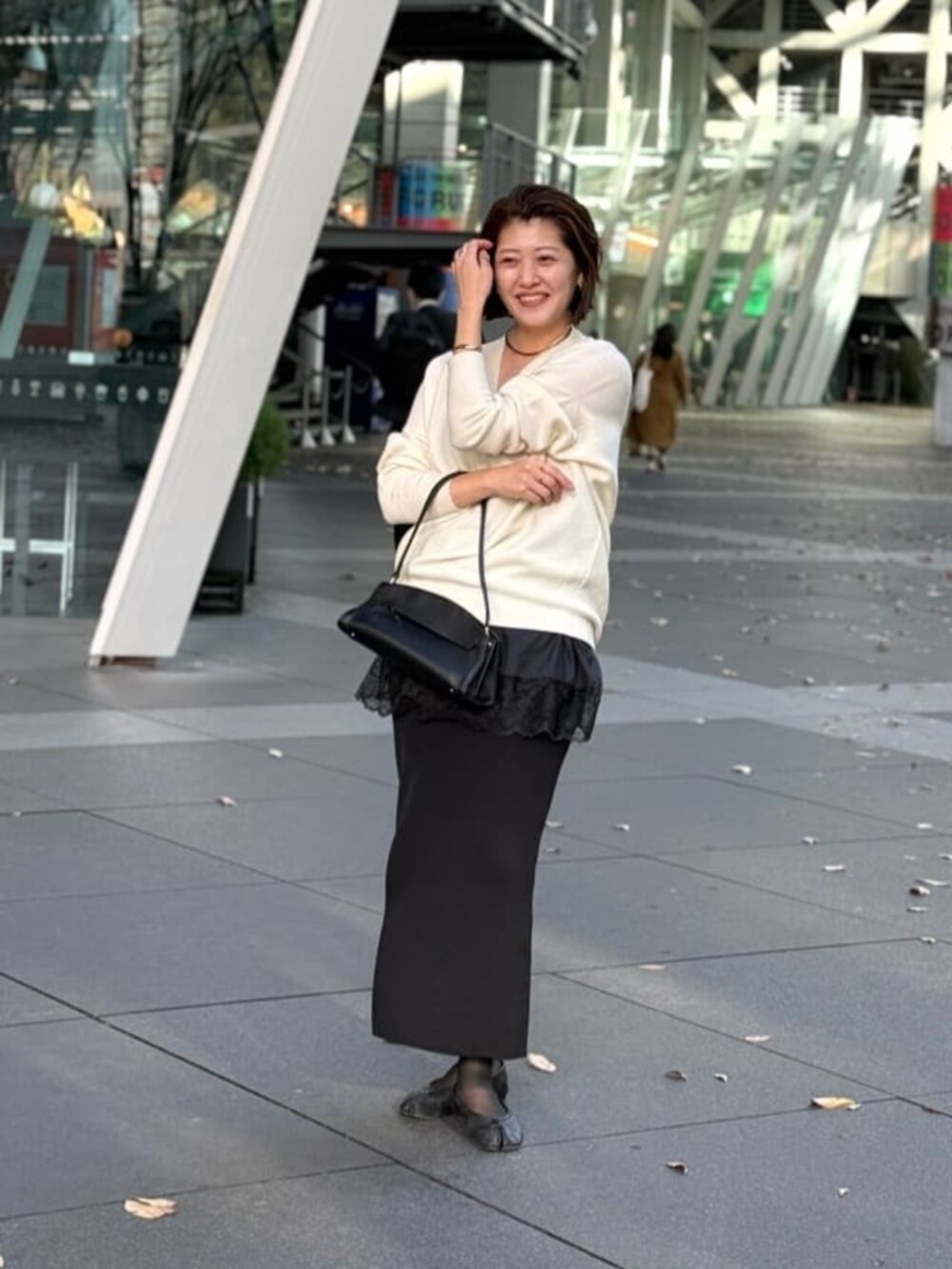 ブラック系のスカート、ブラック系のハンドバッグ、ブラック系のキャミソールを着用したレディースの冬コーディネートの6枚目の写真