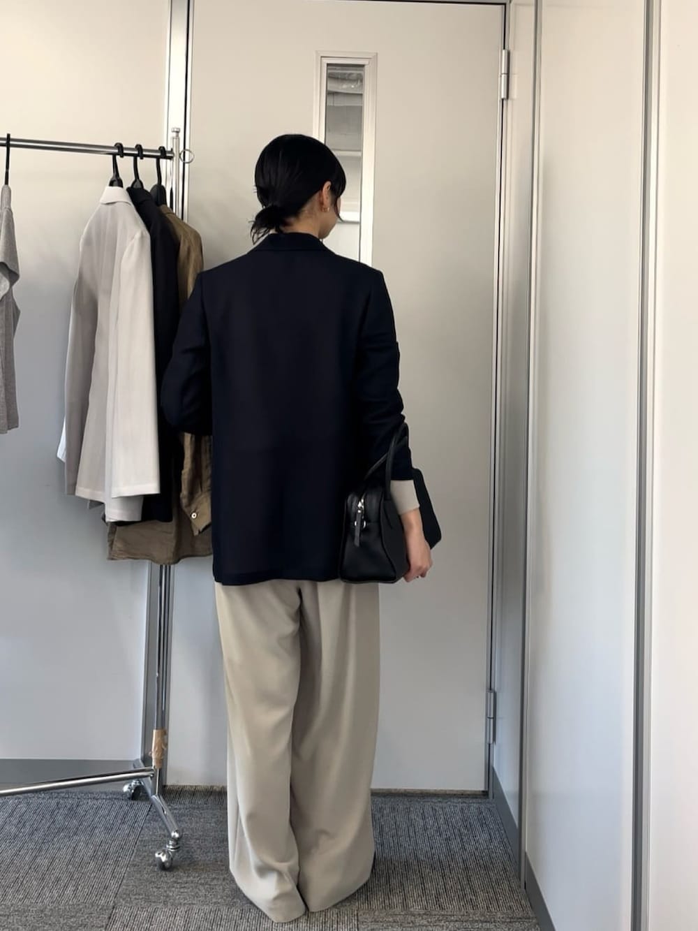 ブルー系のテーラードジャケット、グレー系のスラックスを着用したレディースの春コーディネートの4枚目の写真