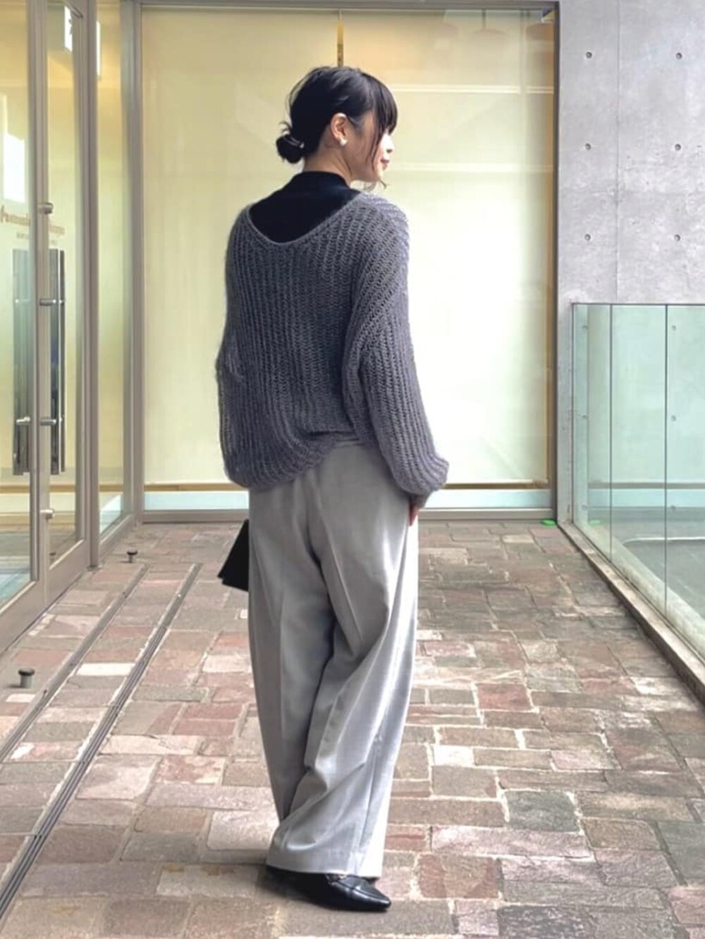 ホワイト系のニット/セーター、グレー系のその他パンツ、ブラック系のローファーを着用したレディースの冬コーディネートの3枚目の写真