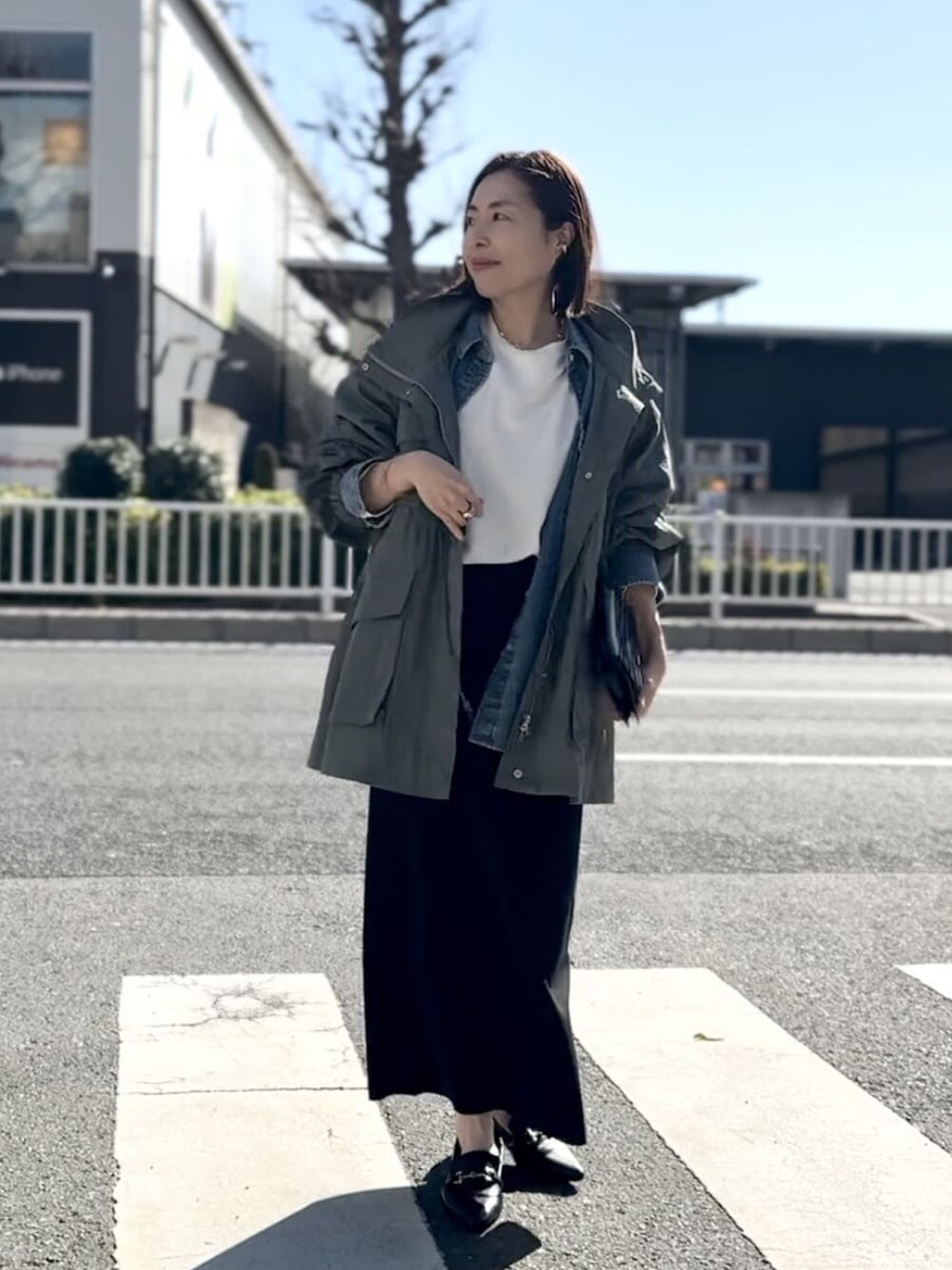 ホワイト系のTシャツ/カットソー、ブラック系のスカート、ブラック系のローファーを着用したレディースの冬コーディネートの3枚目の写真