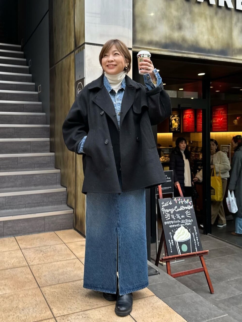 ブルー系のジャンパースカート、ブラック系のブーツを着用したレディースの冬コーディネートの4枚目の写真