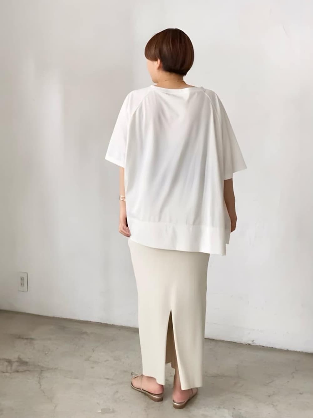 ブラック系のTシャツ/カットソー、ホワイト系のスカート、シルバー系のサンダルを着用したレディースの春コーディネートの3枚目の写真