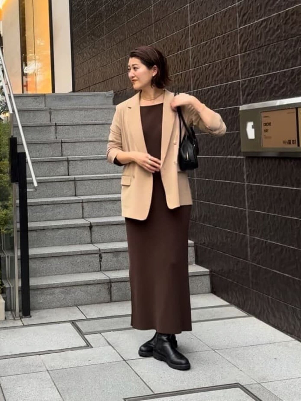 ブラウン系のワンピース、イエロー系のテーラードジャケット、ブラック系のショルダーバッグを着用したレディースの秋コーディネートの2枚目の写真