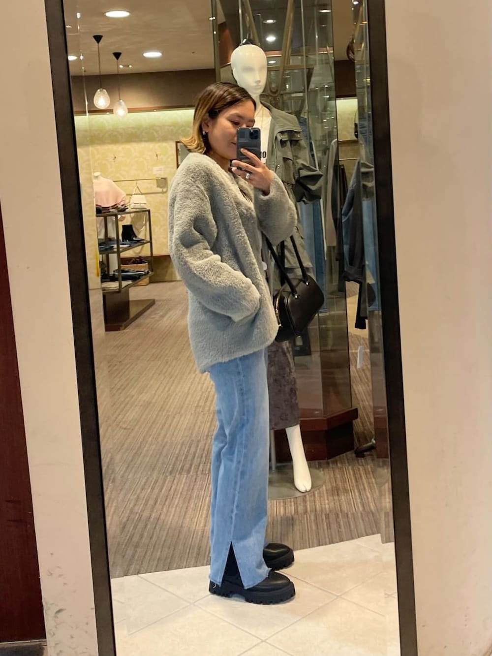 グレー系のカーディガン/ボレロ、ブルー系のデニムパンツを着用したレディースの秋コーディネートの2枚目の写真