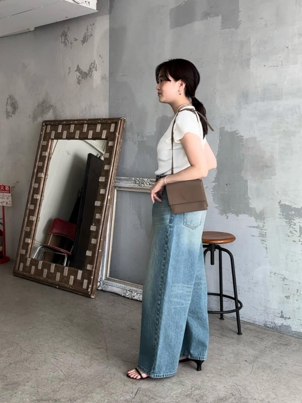 ホワイト系のニット/セーター、ブルー系のデニムパンツ、ブラック系のサンダルを着用したレディースの春コーディネートの2枚目の写真