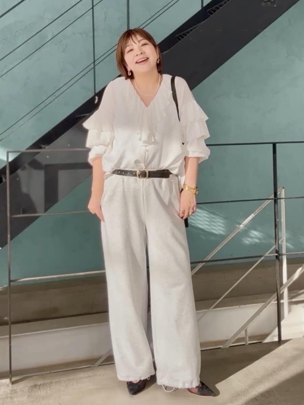 ブラック系のパンプス、グレー系のスウェットパンツ、ホワイト系のシャツ/ブラウスを着用したレディースの春コーディネートの3枚目の写真