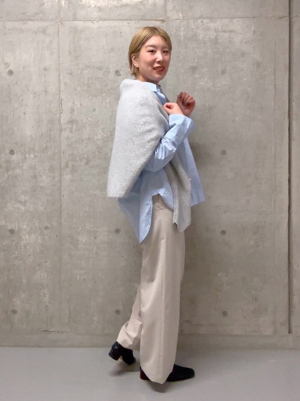 ブルー系のシャツ/ブラウス、ベージュ系のその他パンツ、グレー系のニット/セーターを着用したレディースの冬コーディネートの3枚目の写真