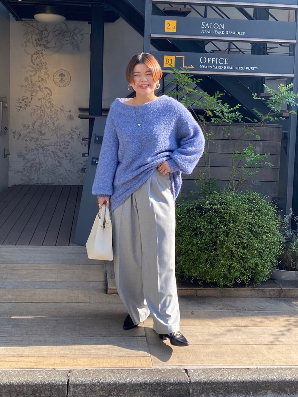 ブルー系のニット/セーター、グレー系のその他パンツ、ブラック系のローファーを着用したレディースの秋コーディネートの4枚目の写真