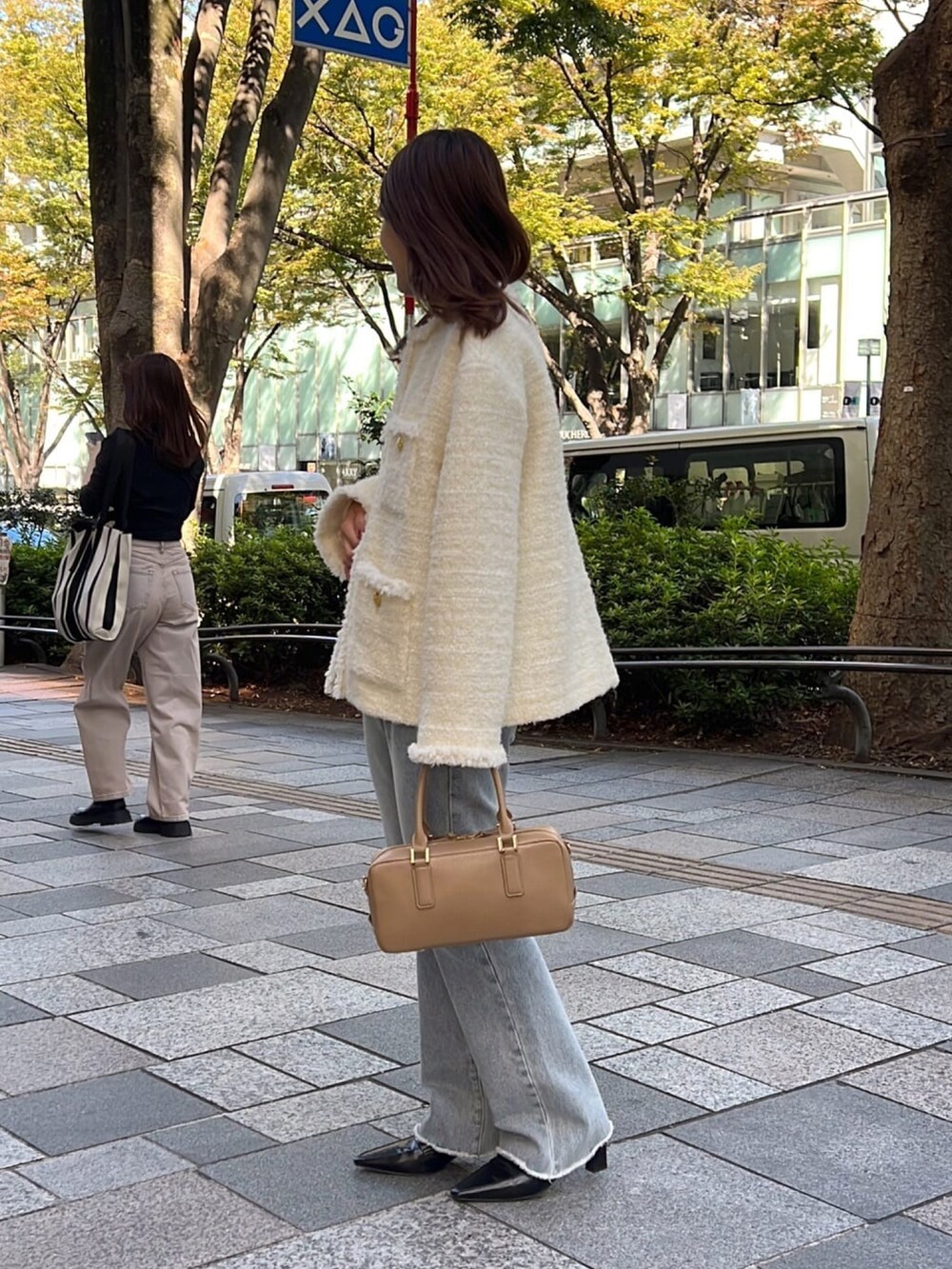 ホワイト系のその他アウター、ブルー系のデニムパンツ、イエロー系のボストンバッグを着用したレディースの冬コーディネートの3枚目の写真