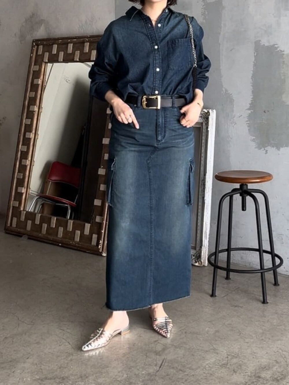 ブルー系のデニムスカート、ブラック系のショルダーバッグ、ブルー系のシャツ/ブラウスを着用したレディースの春コーディネートの4枚目の写真