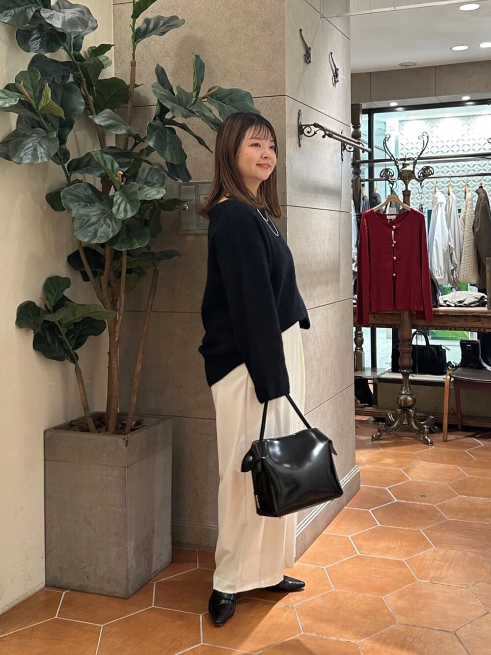 ブラック系のニット/セーター、グレー系のスラックス、ブラック系のローファーを着用したレディースの冬コーディネートの2枚目の写真