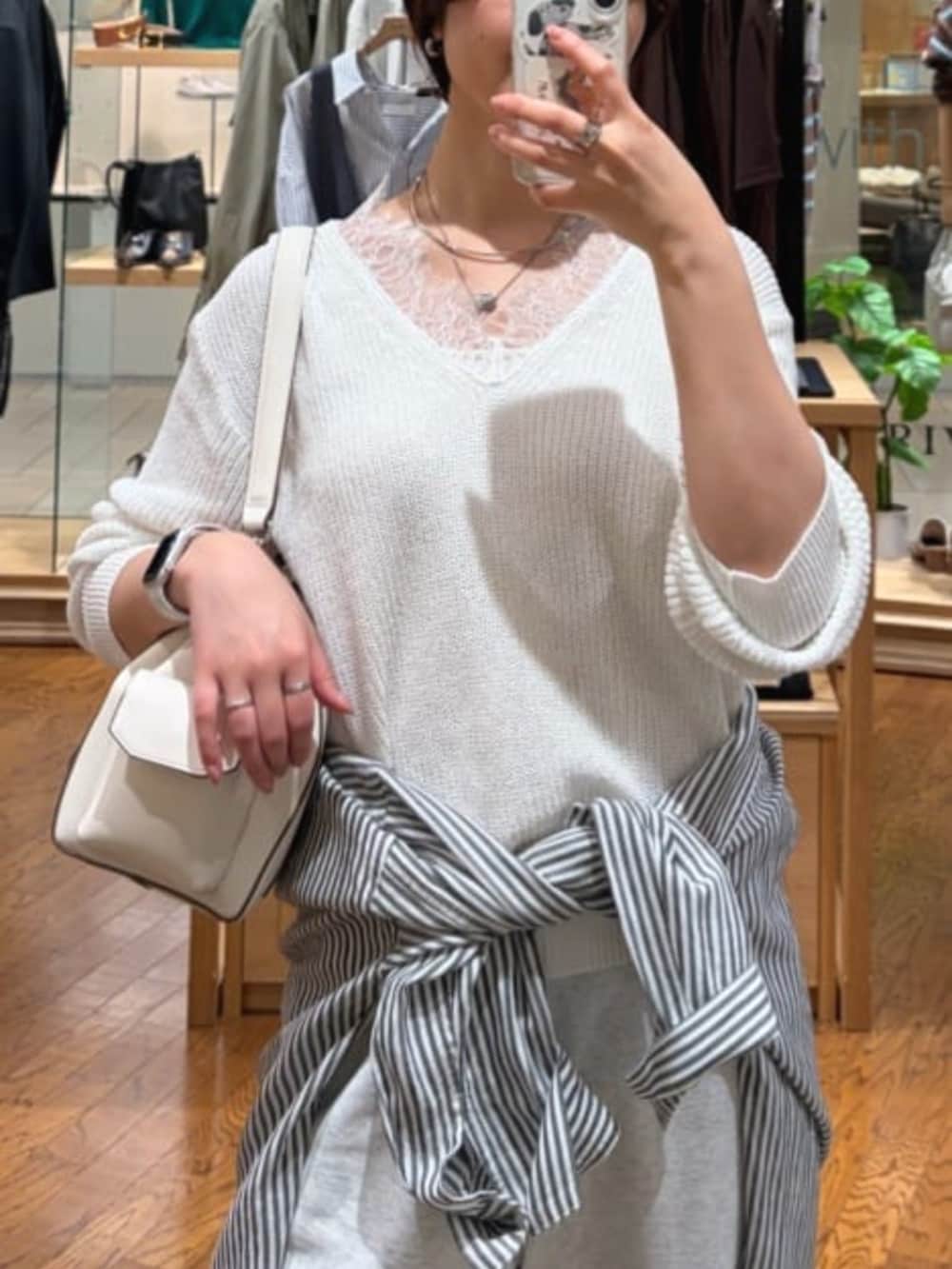 グレー系のスウェットパンツ、ホワイト系のニット/セーター、ホワイト系のショルダーバッグを着用したレディースの春コーディネートの2枚目の写真