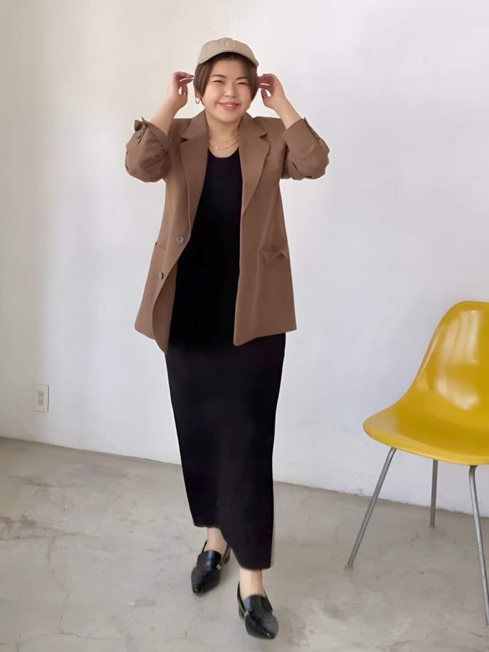 ブラウン系のテーラードジャケット、ブラック系のワンピース、ブラック系のローファーを着用したレディースの春コーディネートの3枚目の写真