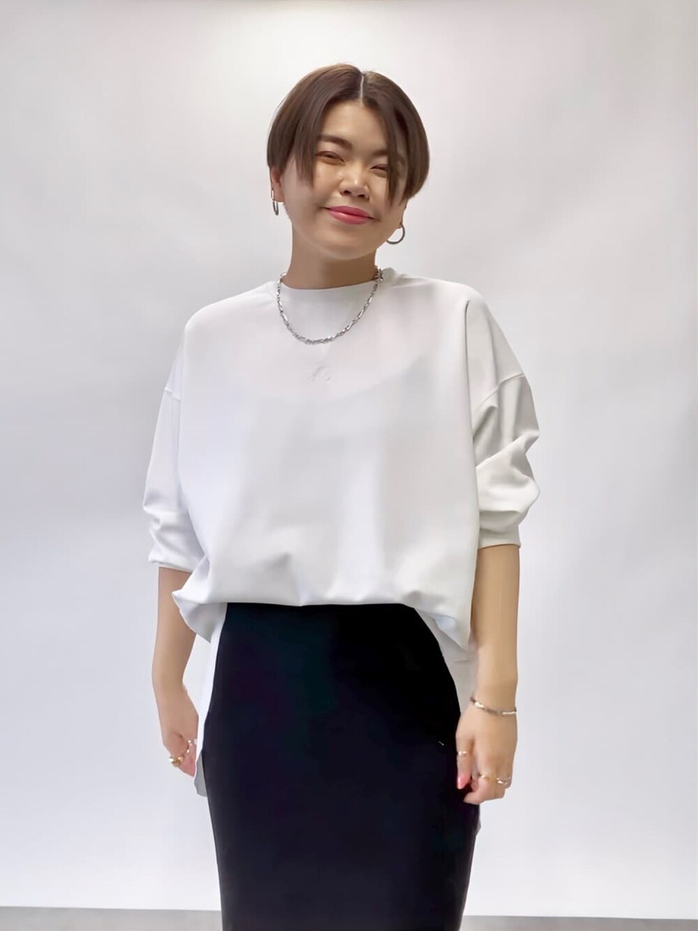 ホワイト系のTシャツ/カットソー、ブラック系のスカート、ブラック系のローファーを着用したレディースの冬コーディネートの4枚目の写真