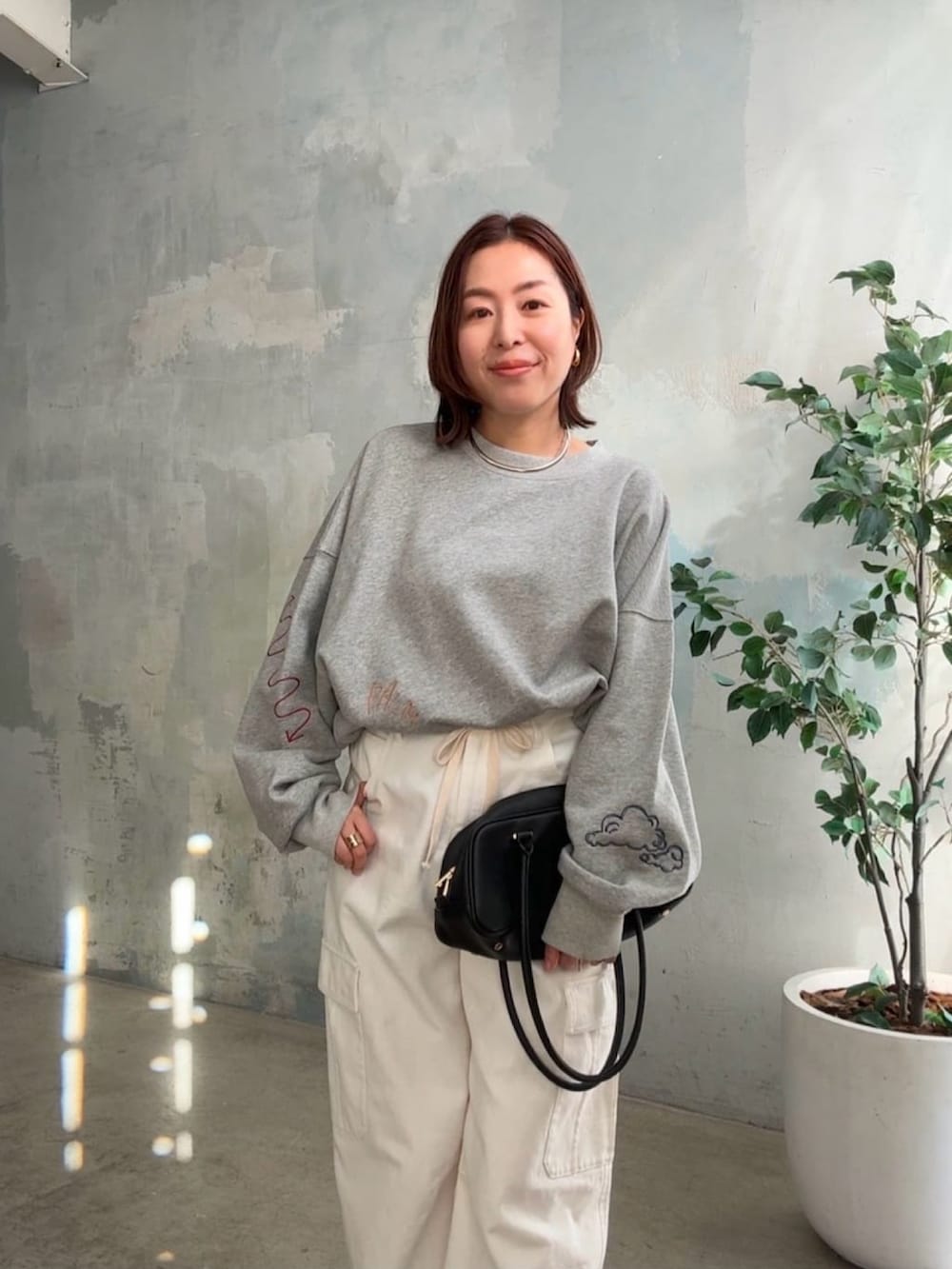 グレー系のTシャツ/カットソー、ホワイト系のカーゴパンツ、ブラック系のパンプスを着用したレディースの冬コーディネートの4枚目の写真