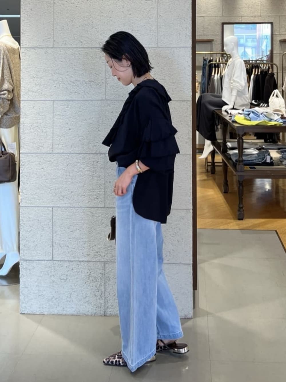 グレー系のトートバッグ、ブラック系のシャツ/ブラウス、ブルー系のデニムパンツを着用したレディースの春コーディネートの4枚目の写真