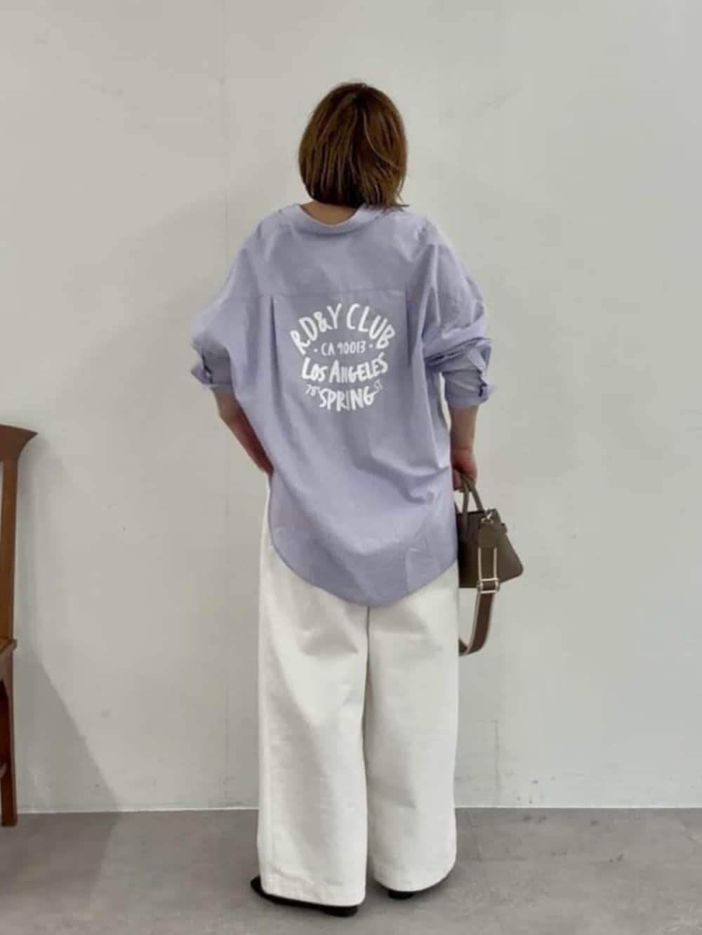 グレー系のトートバッグ、ホワイト系のデニムパンツ、ブラック系のその他シューズを着用したレディースの春コーディネートの2枚目の写真