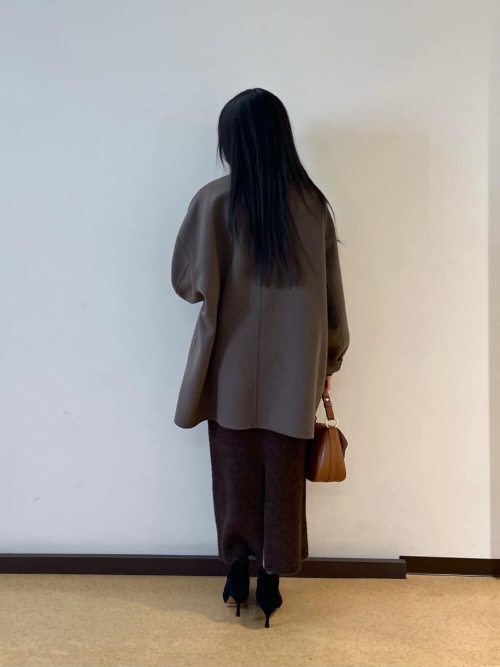 ブラウン系のその他アウター、ブラウン系のカーディガン/ボレロ、ブラウン系のスカートを着用したレディースの冬コーディネートの3枚目の写真