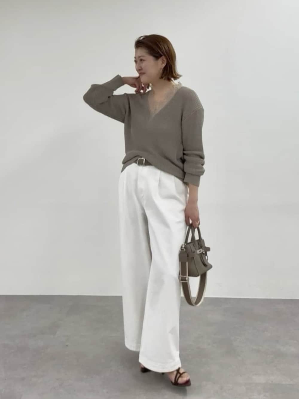 ブラウン系のテーラードジャケット、ホワイト系のデニムパンツ、ホワイト系のボストンバッグを着用したレディースの春コーディネートの4枚目の写真