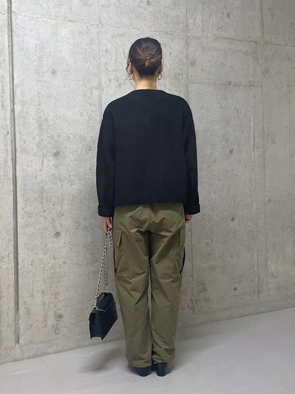グリーン系のカーゴパンツ、ブラック系のカーディガン/ボレロ、ブラック系のハンドバッグを着用したレディースの秋コーディネートの3枚目の写真
