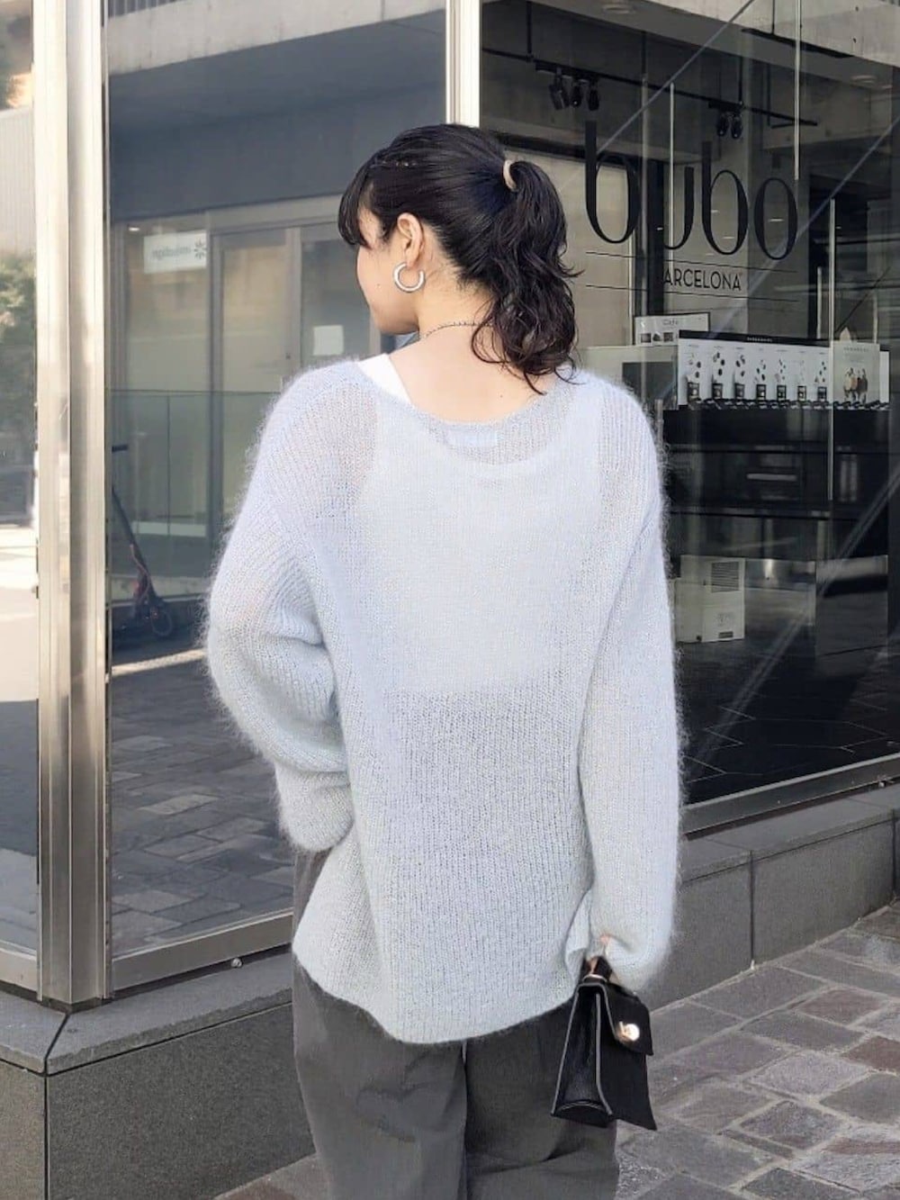 ブルー系のニット/セーター、グレー系のその他パンツを着用したレディースの冬コーディネートの4枚目の写真