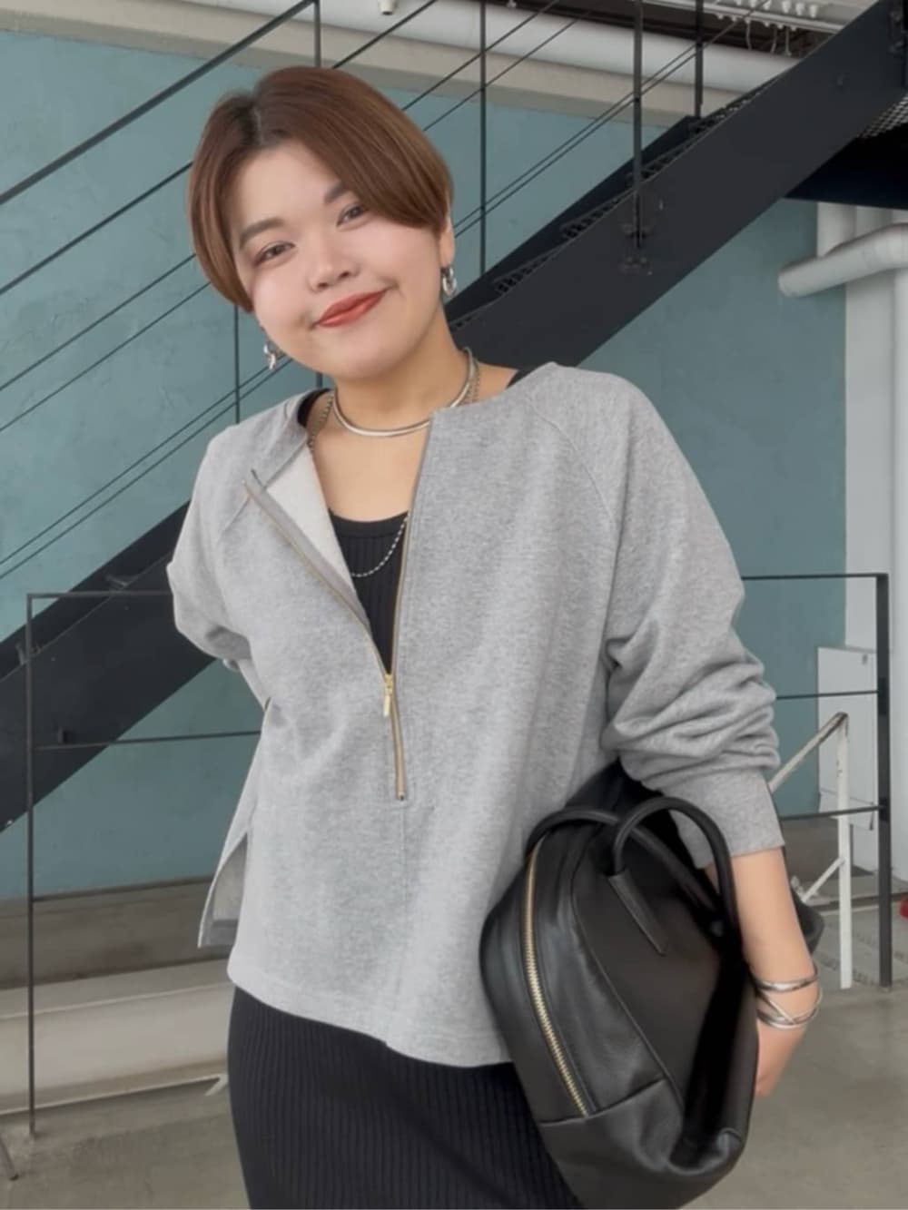 グレー系のスウェット、ブラック系のワンピース、シルバー系のチョーカーを着用したレディースの春コーディネートの5枚目の写真