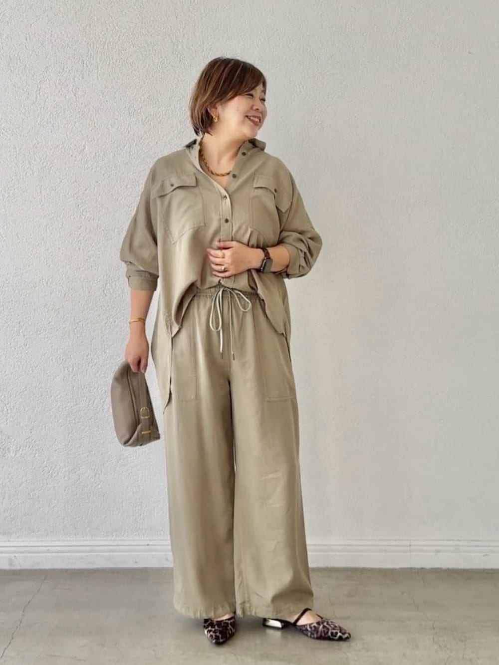 ベージュ系のその他シューズ、グリーン系のシャツ/ブラウス、ベージュ系のショルダーバッグを着用したレディースの春コーディネートの7枚目の写真