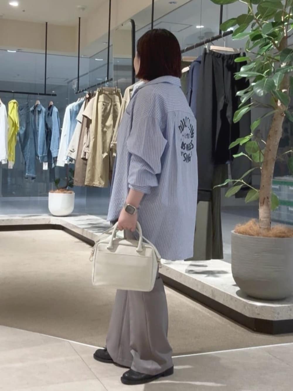 ホワイト系のボストンバッグ、ブルー系のシャツ/ブラウス、ブラック系のキャミソールを着用したレディースの春コーディネートの2枚目の写真