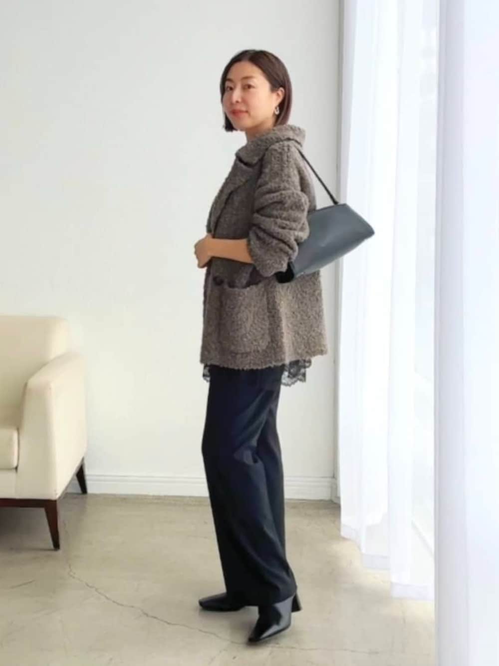 ブラック系のブーツ、ブラック系のキャミソール、ブラウン系のその他アウターを着用したレディースの冬コーディネートの2枚目の写真