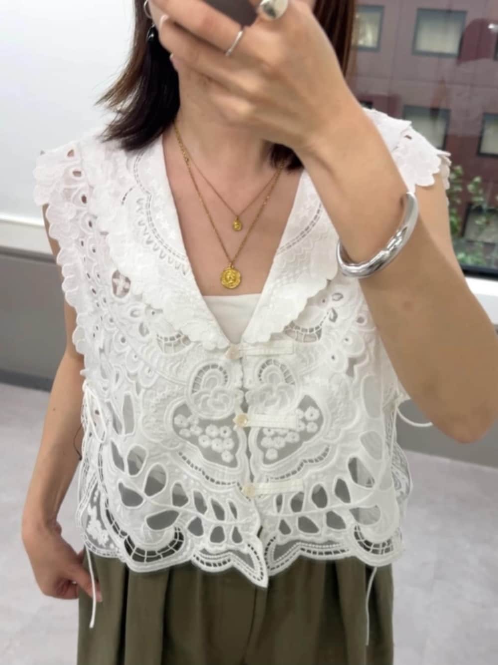 グリーン系のその他パンツ、ホワイト系のベスト、ベージュ系のサンダルを着用したレディースの夏コーディネートの3枚目の写真