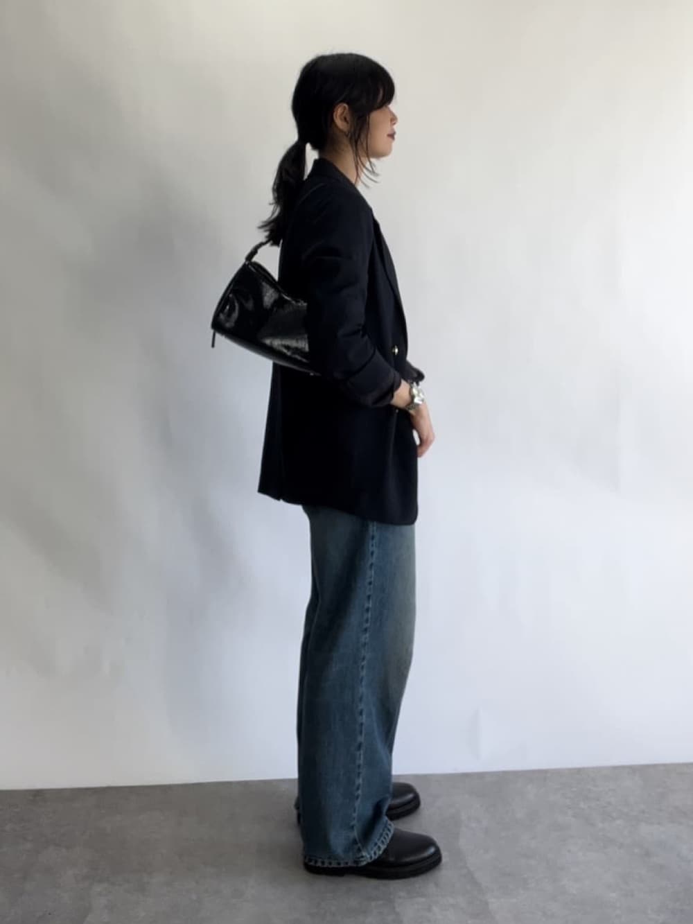 ブルー系のデニムパンツ、グレー系のTシャツ/カットソー、ブルー系のテーラードジャケットを着用したレディースの秋コーディネートの3枚目の写真