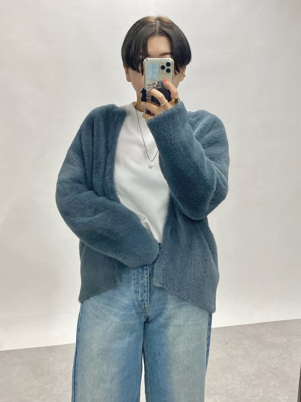 ブルー系のカーディガン/ボレロ、ブルー系のデニムパンツ、ブラック系のTシャツ/カットソーを着用したレディースの秋コーディネートの2枚目の写真